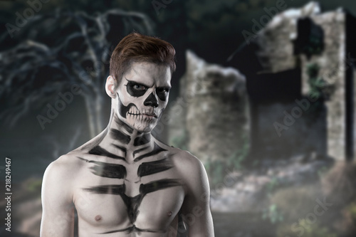 Halloween concept with young man in day of the dead mask face art
