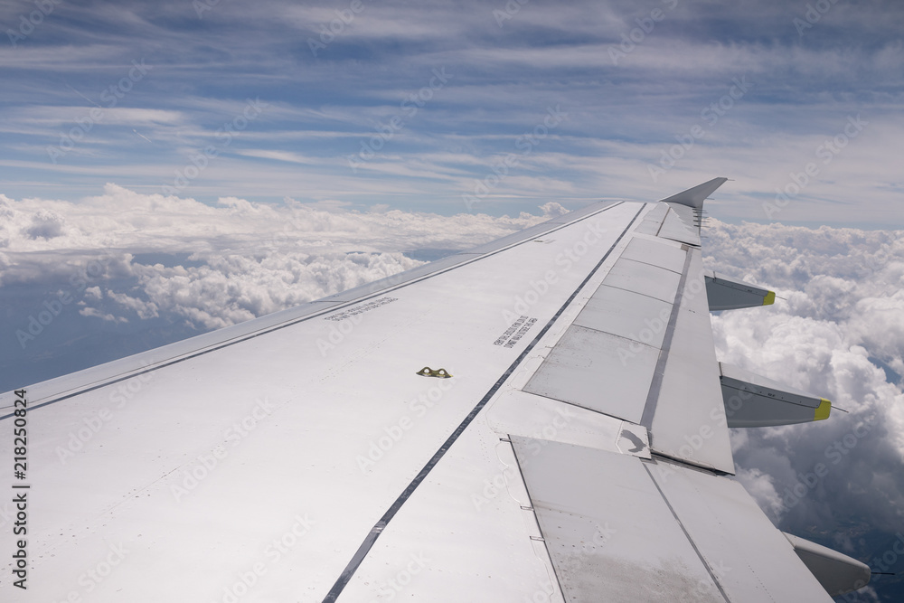 Airplane wing in the sky with clouds