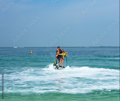 Father and his daughter posing at new flyboard at Caribbean tropical beach. Positive human emotions, feelings, joy. Funny cute child making vacations and enjoying summer.