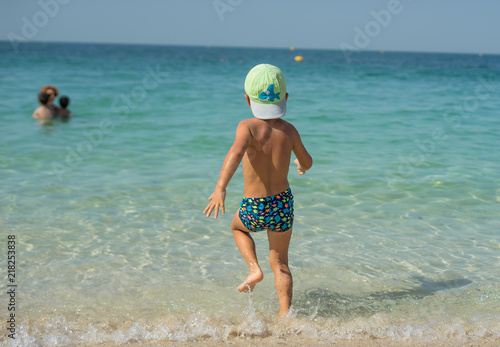Portrait smiling little baby boy playing in the sea, ocean. Positive human emotions, feelings, joy. Funny cute child making vacations and enjoying summer.