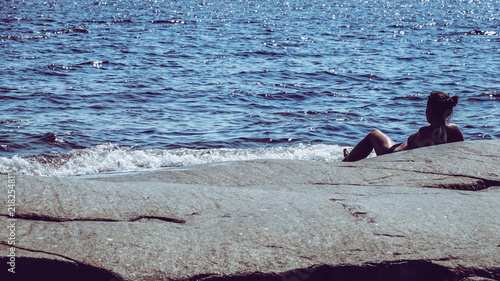 Woman lying on a rock in th...