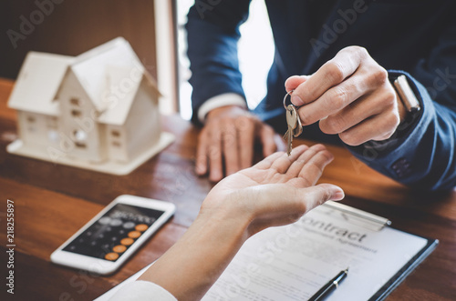 Real estate agent Sales manager holding filing keys to customer after signing rental lease contract of sale purchase agreement, concerning mortgage loan offer for and house insurance photo
