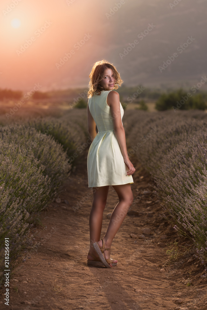 Happy young woman in a yellow dress  in a lavender field