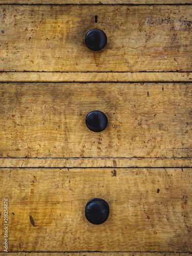 Close up of three rustic wooden drawers of an antique dresser