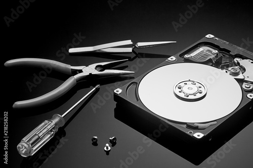 disassembled hard drive and tools are on the operating table