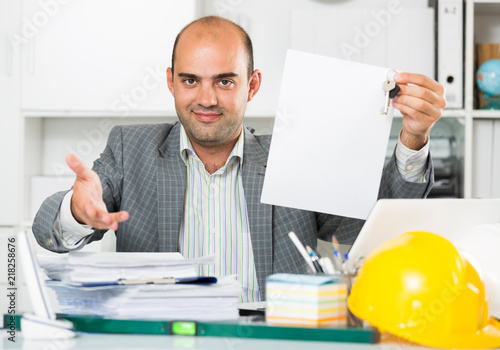 Employee  sitting near helmet at the table photo