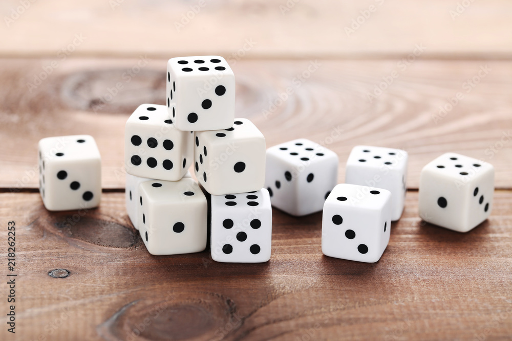 White dice on brown wooden table White dice on brown wooden table