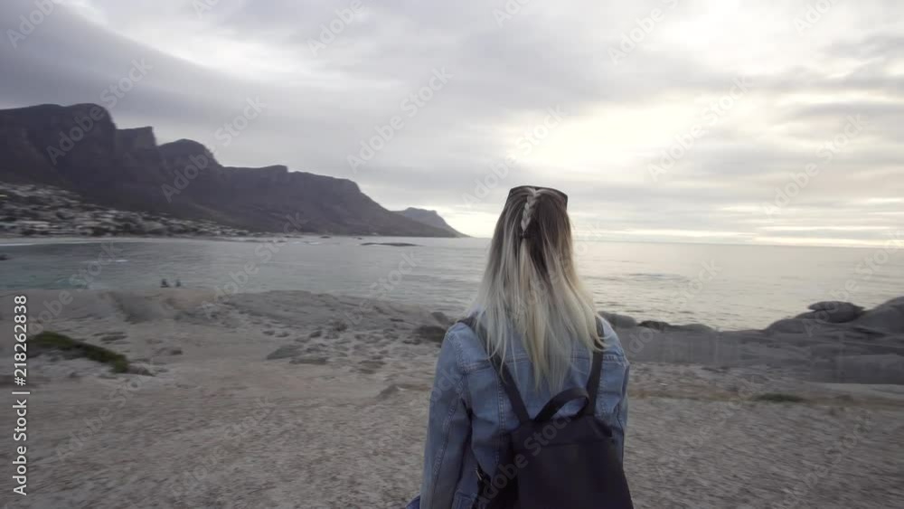 Woman looking at Table Mountain and the Coast of Cape Town, South Africa during Sunset in Camps Bay Woman looking at Table Mountain and the Coast of Cape Town, South Africa during Sunset in Camps Bay