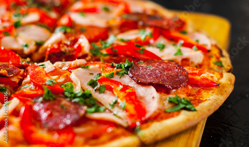 slices of Pizza with Mozzarella cheese, Ham, Tomatoes, salami, pepper, pepperoni Spices and Fresh Basil. Italian pizza