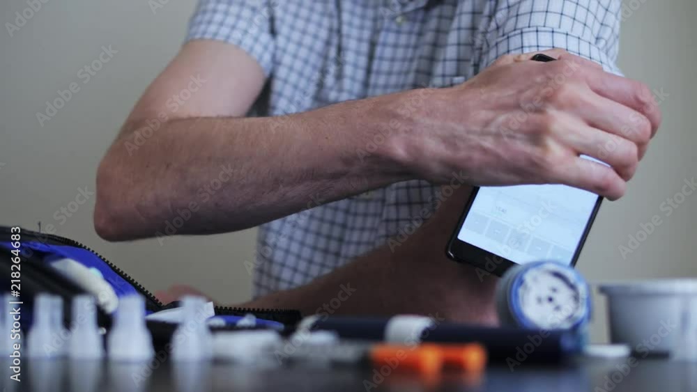 A man hands brings to the hand the smartphone for measuring glucose in the blood A man hands brings to the hand the smartphone for measuring glucose in the blood