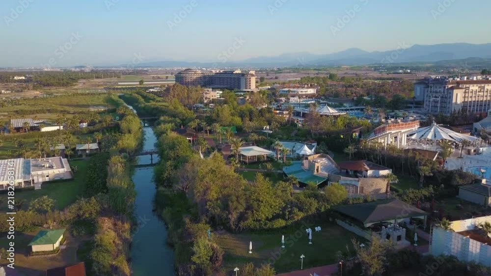 A view from above, the flight of the drone along the river above the trees and buildings. A view from above, the flight of the drone along the river above the trees and buildings.