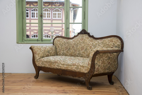 altes barocke Sofa in einem restaurierten leeren Raum mit Fenster photo