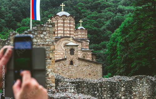 Man taking a photo of a Serbian ortodox monastery Ravanica, built in 14th century photo