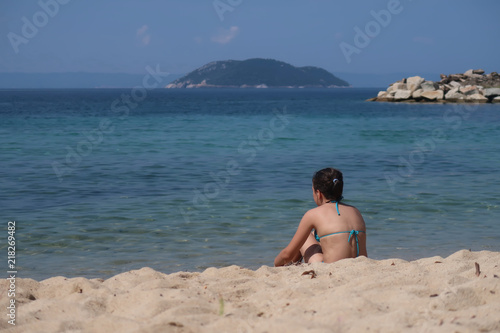 A girl on the beach looking at the sea