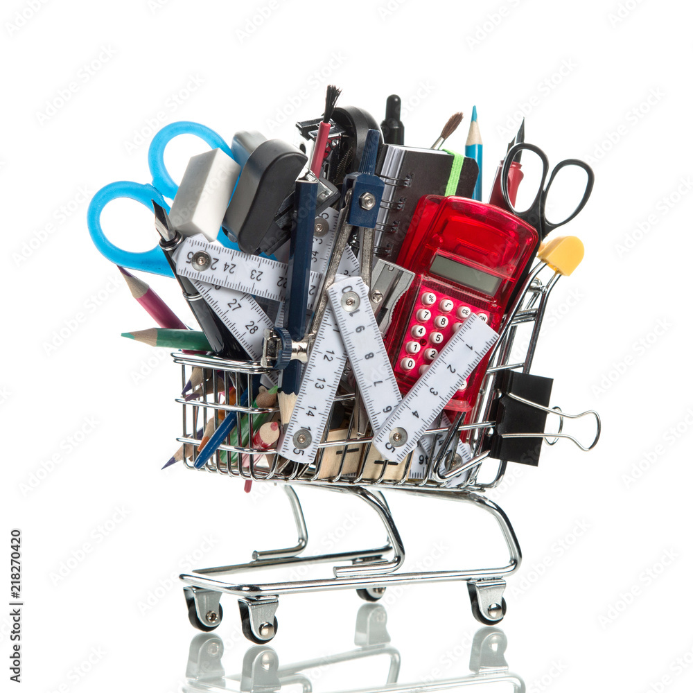 Shopping cart / trolley with school supplies on white isolated background. Back to school background.