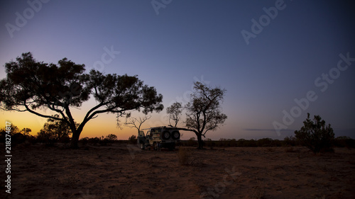 Sunrise with trees in silhouette in the Australian outback.