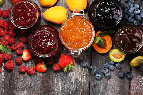 assortment of jams, seasonal berries, apricot, mint and fruits. marmalade or confiture photo
