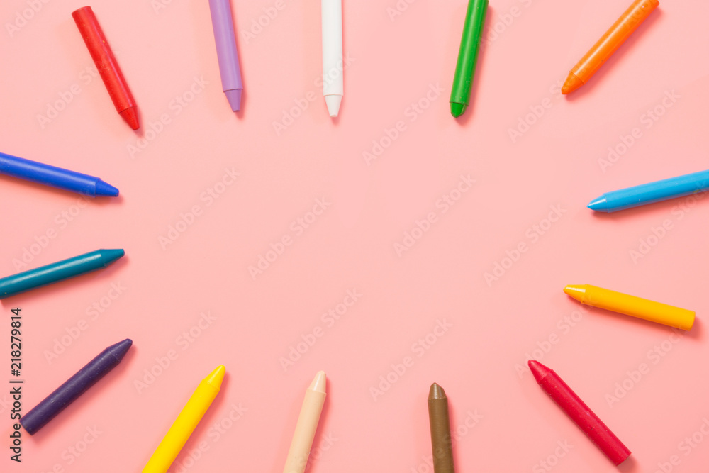Back to school. Colorful wax crayons on pink. Copy space. Top view. Back to school. Colorful wax crayons on pink. Copy space. Top view.