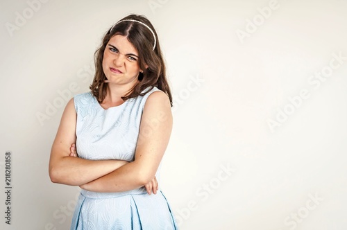 Billede på lærred A beautiful pouted and capricious Caucasian brunette girl with crossed hands making unhappy faces
