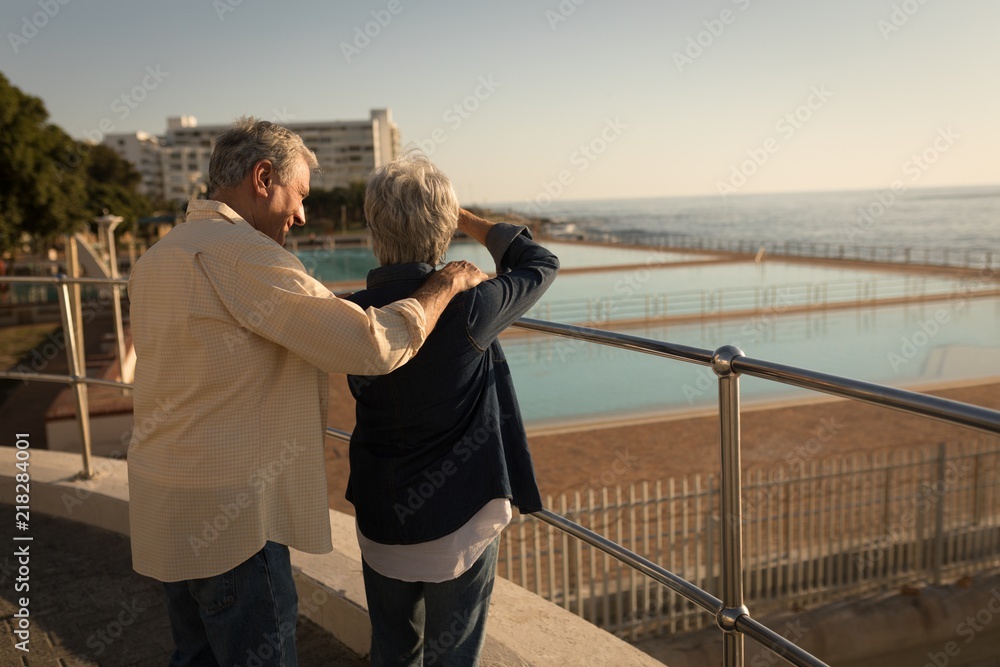 Senior couple standing at promenade near sea Senior couple standing at promenade near sea