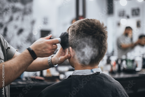 Men's haircut in the beauty salon. Barber makes a haircut to the client. Preparing for a haircut.