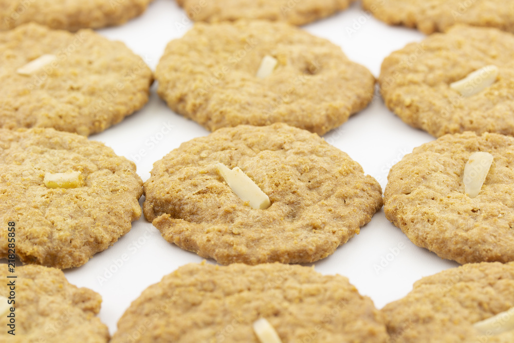 row of cookies with sliced almond on white background row of cookies with sliced almond on white background
