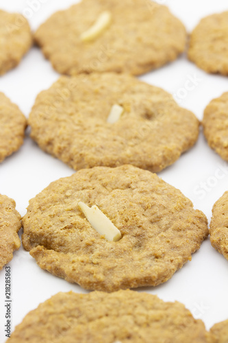 row of cookies with sliced almond on white background