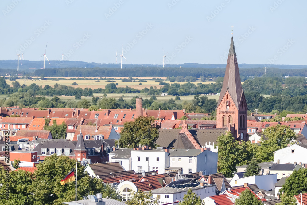Village rooftops with wind turbines in the distance