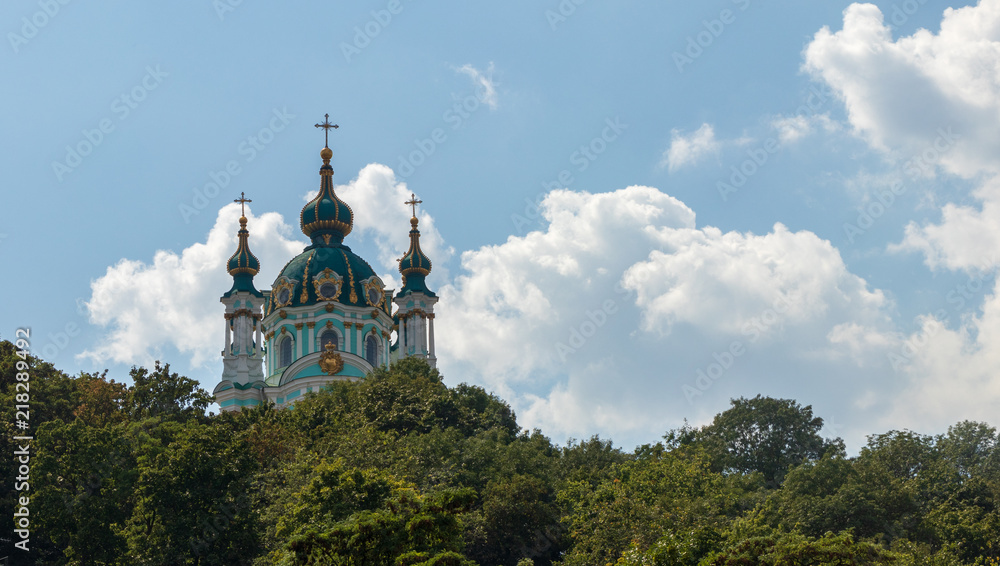 beautiful church standing in green trees on blue sky background