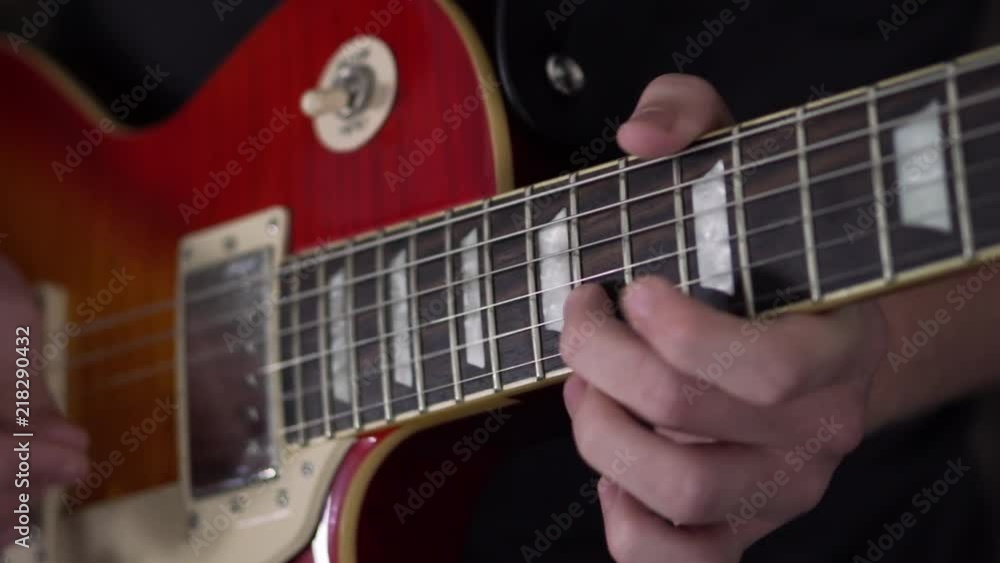 Slo-motion shot of a man quickly picking through a solo on a Les Paul style guitar Slo-motion shot of a man quickly picking through a solo on a Les Paul style guitar