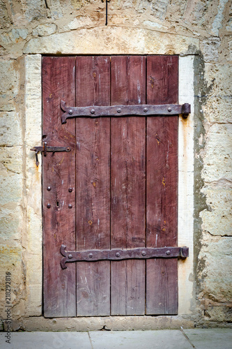 Medieval castle wooden door with massive iron hinges.