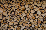Wooden background. Firewood drying for the winter, stacks of firewood
