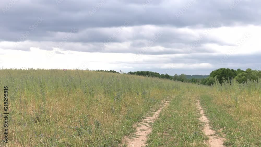 Dirt road. Meadow and sky. Bad weather. Clouds. Panning,Wide angle, Dirt road. Meadow and sky. Bad weather. Clouds. Panning,Wide angle,