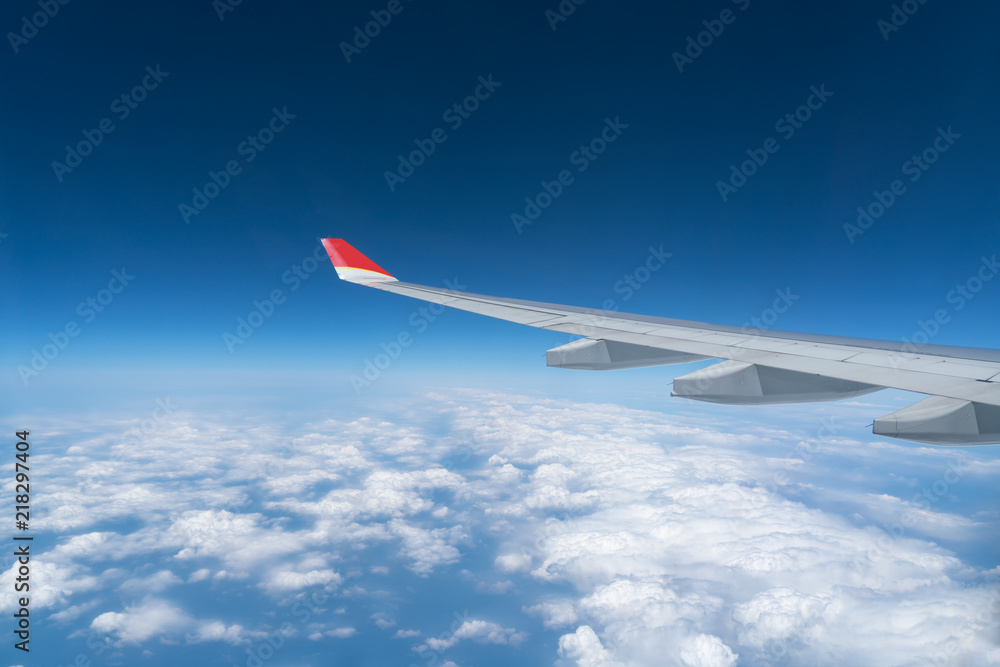 View from airplane window with blue sky and white clouds View from airplane window with blue sky and white clouds