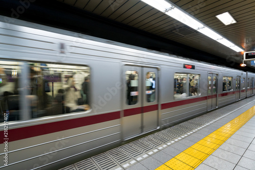 Photography Interior of a Tokyo subway station and platform with subway commuters in Tokyo, Japan