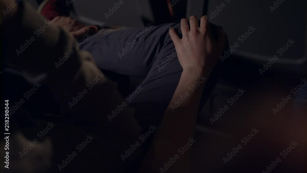 Woman flirting with man in movie theatre. Girl stroking guy on leg with hand in cinema. Female hand gently taking knee of boyfriend in cinema in slow motion. Cinema date Woman flirting with man in movie theatre. Girl stroking guy on leg with hand in cinema. Female hand gently taking knee of boyfriend in cinema in slow motion. Cinema date