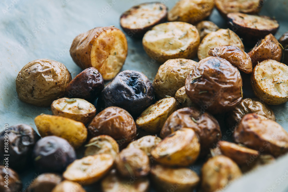 Roasted multicolor creamer potatos on parchment paper. The potato is a starchy, tuberous crop from the perennial nightshade Solanum tuberosum. Slang terms for the potato include tater and spud Roasted multicolor creamer potatos on parchment paper. The potato is a starchy, tuberous crop from the perennial nightshade Solanum tuberosum. Slang terms for the potato include tater and spud