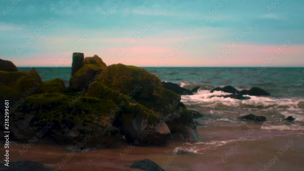 Waves crashing onto rocks at Fort Tilden Beach in Queens, New York during sunset. Waves crashing onto rocks at Fort Tilden Beach in Queens, New York during sunset.