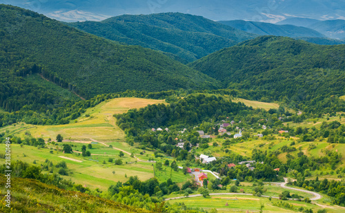 Fototapeta Naklejka Na Ścianę i Meble -  village in the valley. view from the top of a hill. beautiful summer scenery in mountains