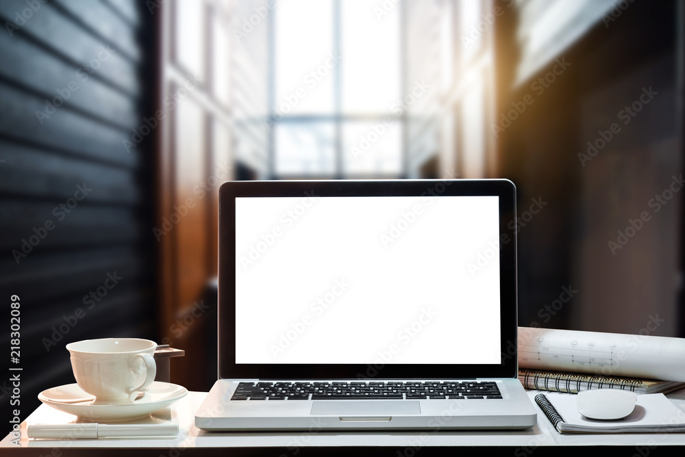 Front view of cup and laptop on table in office and background 