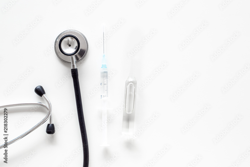 Infuenza vaccine in syringe near stethoscope on white background top view copy space Infuenza vaccine in syringe near stethoscope on white background top view copy space
