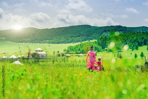 Mother and daughter wearing Mongolian costumes on the grassland