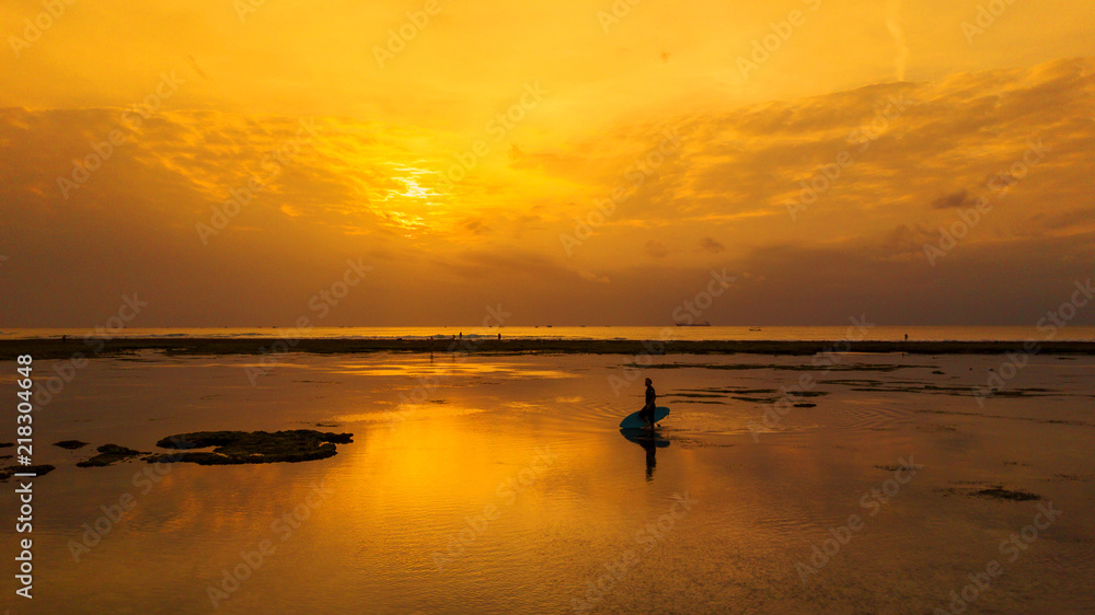 Surfer  at sunset time,Bali island,Indonesia