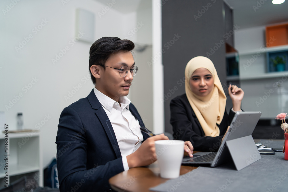 asian malay couple working together at home with laptop and calculator asian malay couple working together at home with laptop and calculator