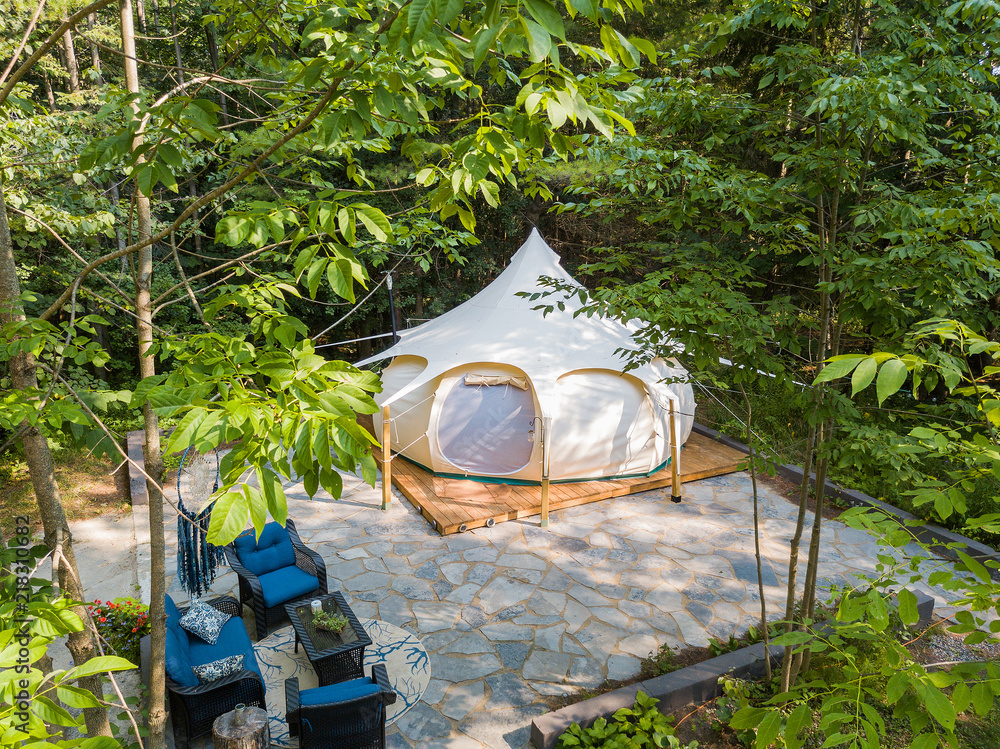 Aerial drone shot of a glamping tent in a forest
