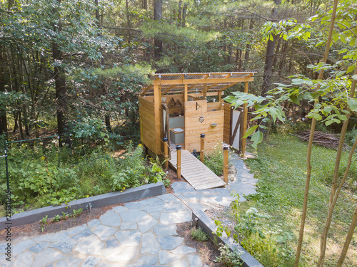 Obraz na płótnie Aerial drone shot of an outdoor shower and composting toilet stall at a glamping site w salonie