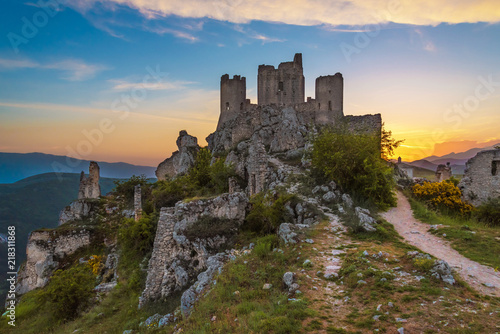 Rocca Calascio (Italy) - The ruins of an old medieval village with castle and church, over 1400 meters above sea level on the Apennine mountains in the heart of Abruzzo, at sunset. photo