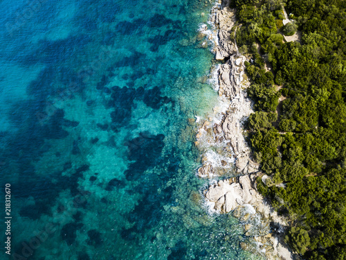 Aerial view of an amazing rocky and green coast bathed by a transparent and turquoise sea. Sardinia, Italy.
