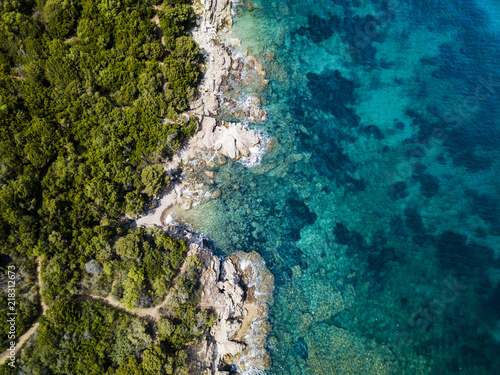 Aerial view of an amazing rocky and green coast bathed by a transparent and turquoise sea. Sardinia, Italy.