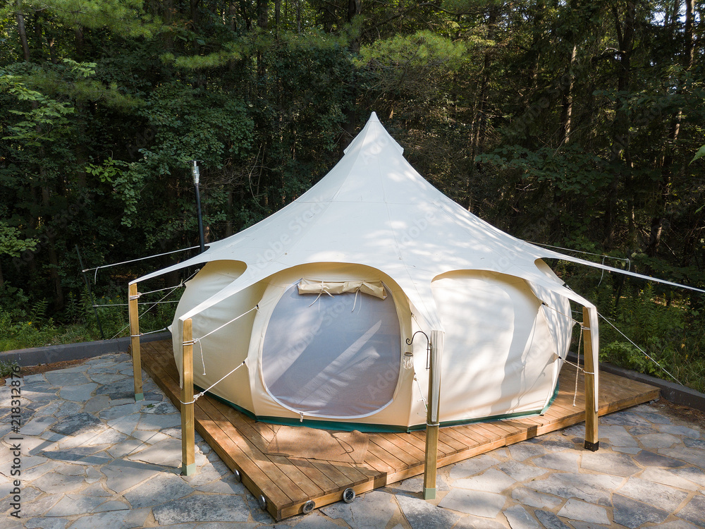 Aerial drone shot of a glamping tent in a forest